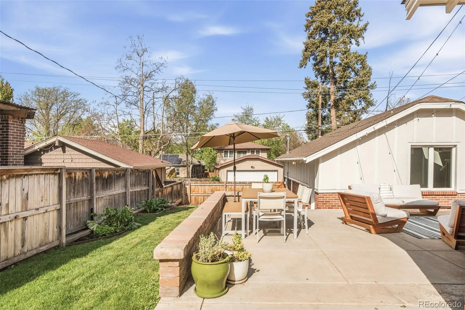 Backyard patio with vegetable garden and detached garage with ADU
